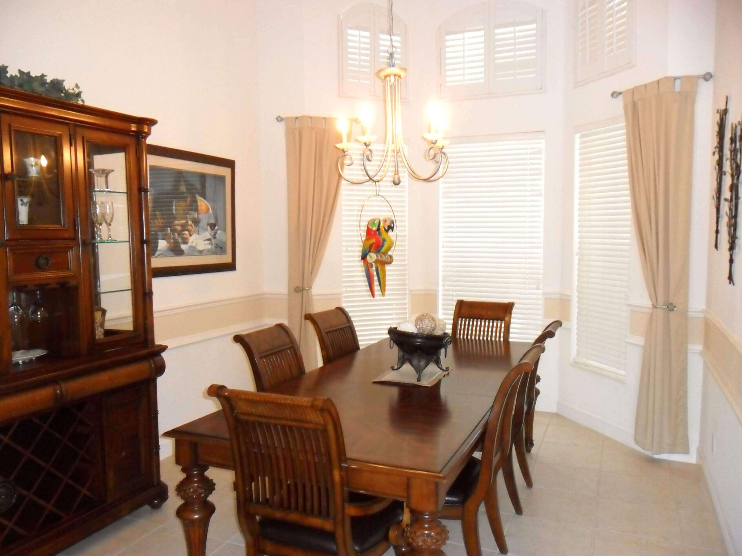 A dining room table and chairs in front of a window.