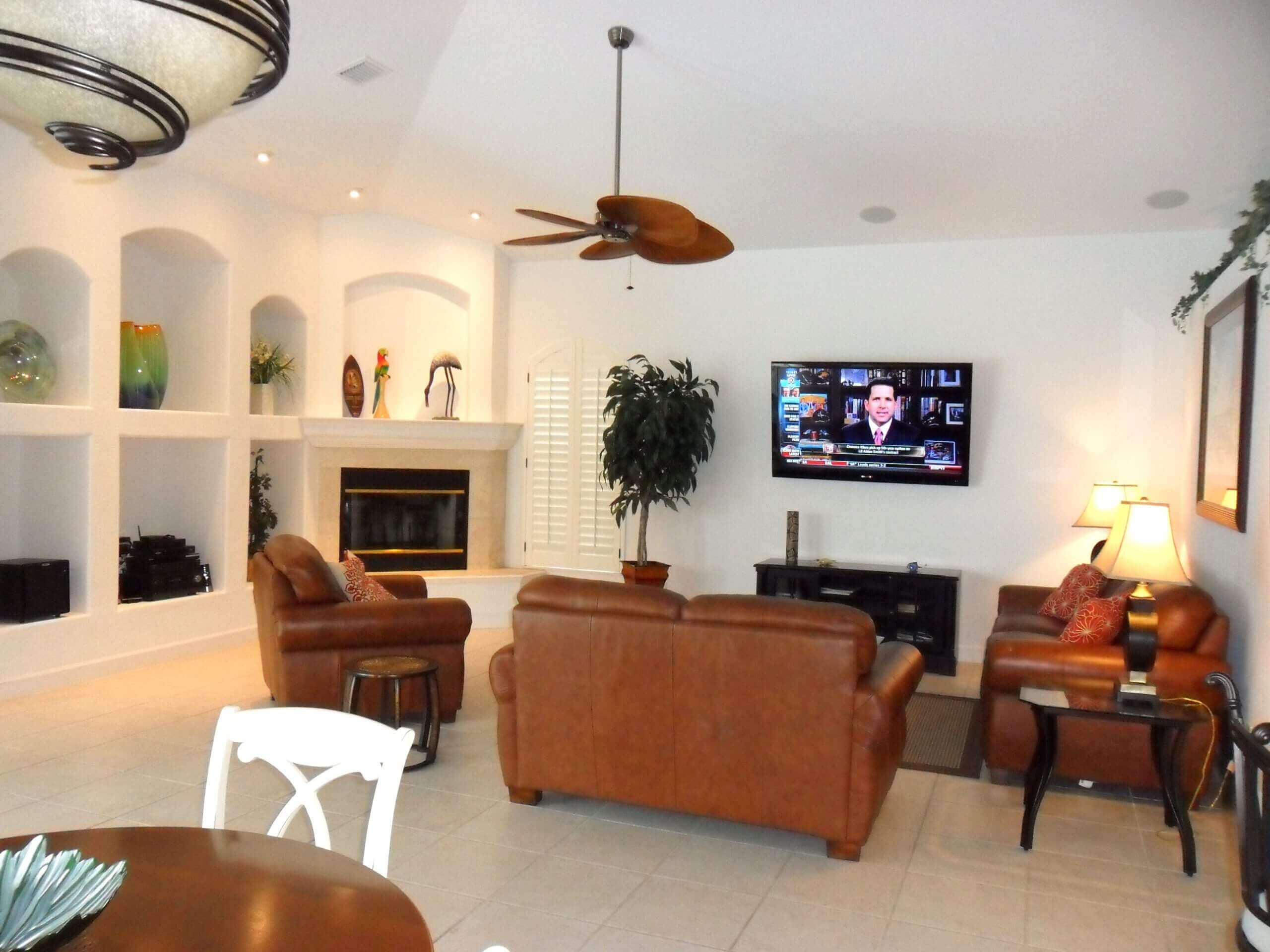 A living room with leather furniture and a flat screen tv.