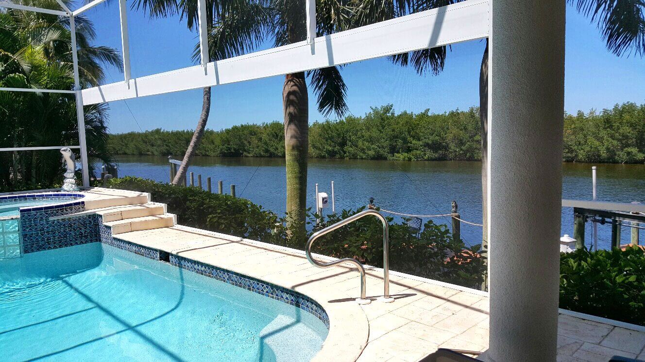 Screened pool deck overlooking tropical canal