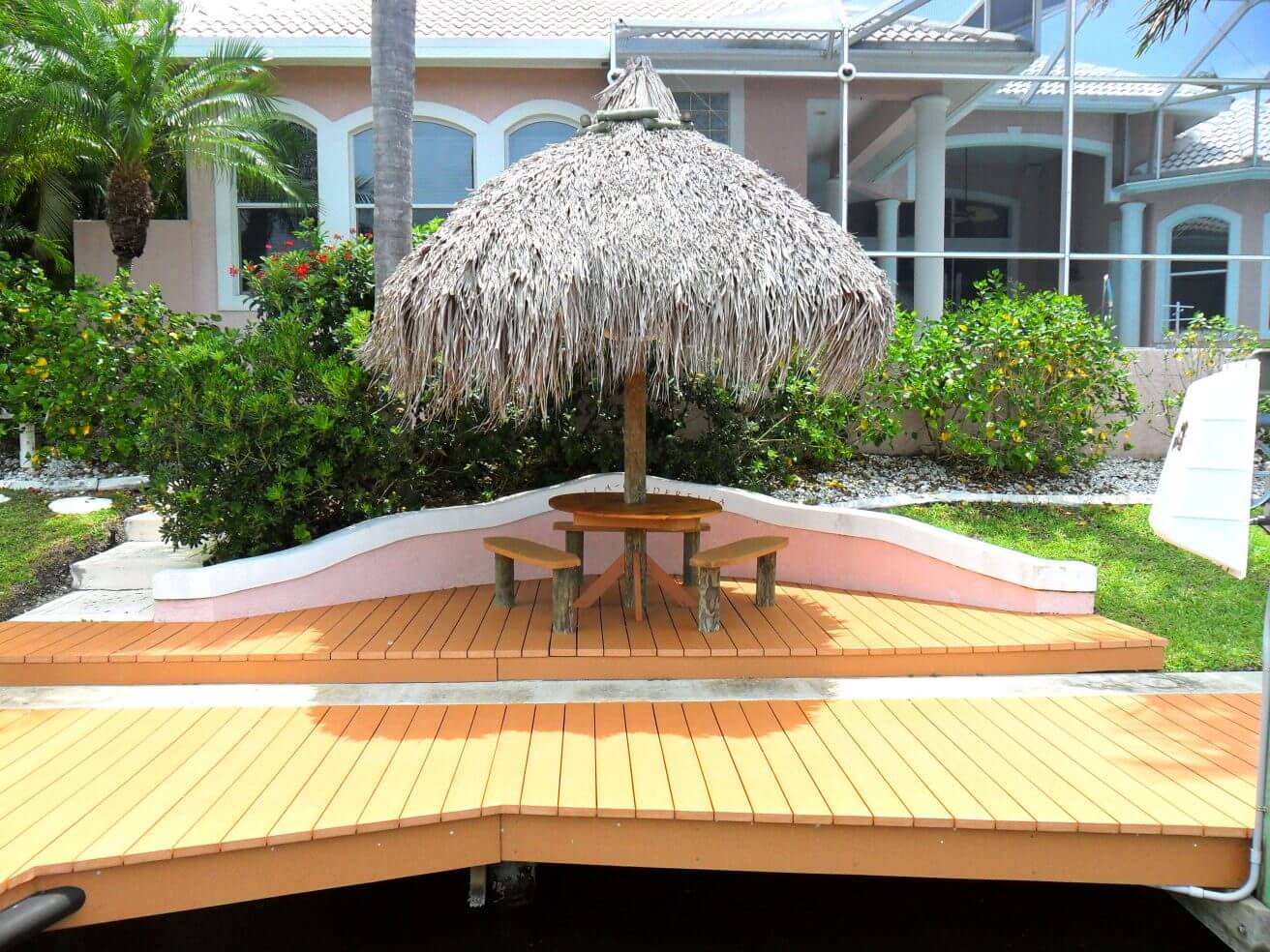 A table and chairs under an umbrella on the deck.