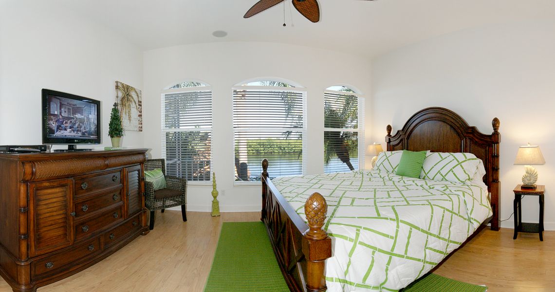 A bedroom with a bed, chair and window.