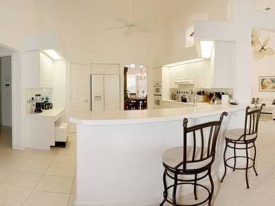 A kitchen with white walls and tile floors.