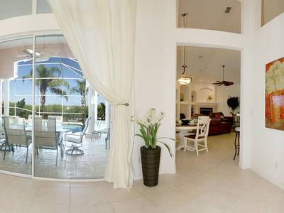 A living room with white curtains and furniture.