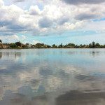 A body of water with houses in the background.