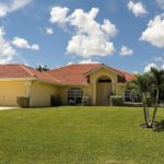 A large house with a palm tree in the yard.