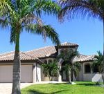 A large house with palm trees in front of it.