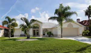 White stucco home with palm trees