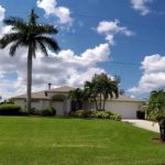 A large house with palm trees in the background.