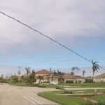 A street with houses and power lines on it.